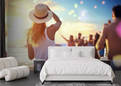 A woman wearing a straw hat stands on a beach with a group of people Wall mural