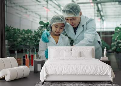 A scientist father guides his daughter in farming using a pH meter. Measuring acid-base levels in water to ensure right conditions for strawberry growth. Combining expertise with technological tools. Wall mural