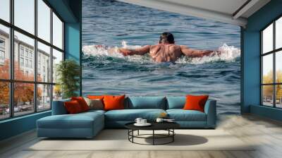 Adult Caucasian man swimming in ocean water. Butterfly Swimming Technique Wall mural