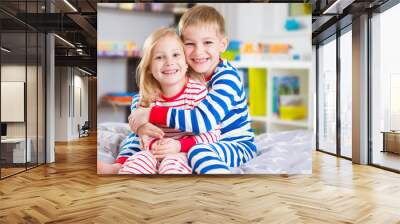 Cute little brother and sister in pajamas Wall mural