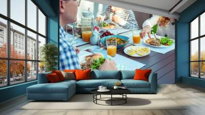 Happy family eating healthy dinner on terrace at home Wall mural