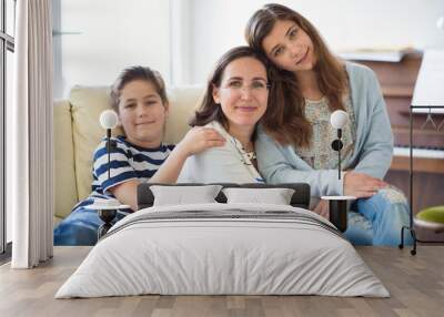 Portrait of pretty young mother with her tennager daughter and son Wall mural