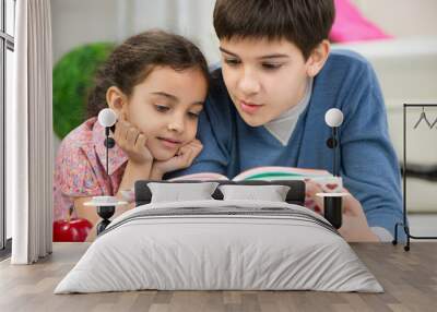 Two children reading book at home Wall mural