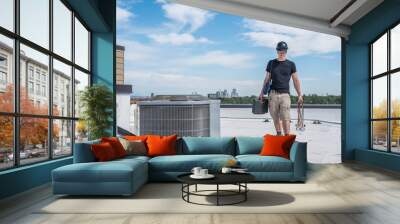 Hvac technician standing by an air conditioner condensing unit on a roof, with downtown Denver skyline, CO, in the background. Wall mural