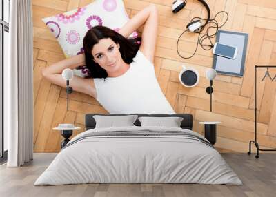 A beautiful young woman laying on the floor, with electronic gad Wall mural