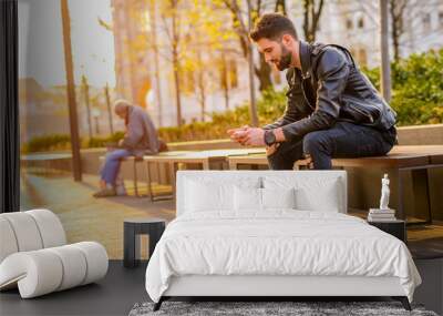 Young man sitting on a bench   Wall mural