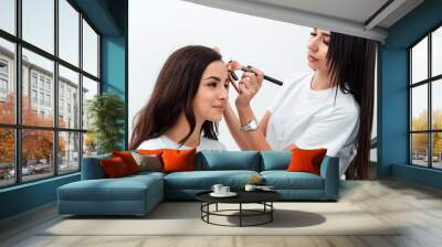 Make up artist doing professional make up of young woman Wall mural