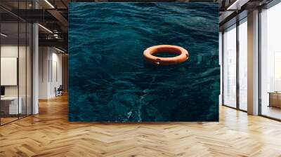 Orange lifebuoy in the blue sea. Lifebuoy - a way to escape Wall mural