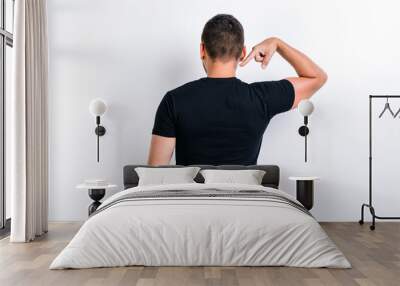 This is me. Back view of proud handsome young man standing and pointing at himself. Indoor studio shot, isolated on white background Wall mural