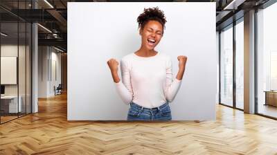 Woman raised hands in success gesture and screams in studio. Concept gesture - Image Wall mural