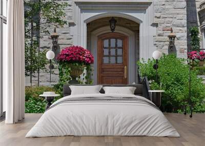 Stone house with elegant wooden  front door and decorative flower pots Wall mural