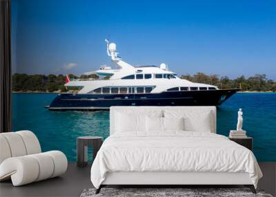 Beautiful shot of the yacht sailing on the water with a blue sky in the background Wall mural