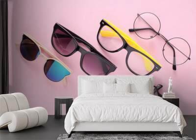 Assorted sunglasses and eyeglasses on a pink background Wall mural