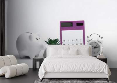 Calculator with piggy banks and alarm clock on white background Wall mural