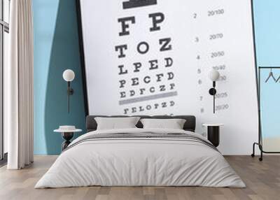 Eyeglasses and Eye test chart on blue beige background. Vision examination Wall mural