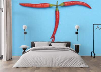 Letter T made from red chilli peppers on blue background Wall mural