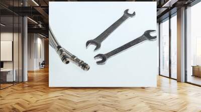 Metal plumbing hoses, wrenches isolated on white background Wall mural