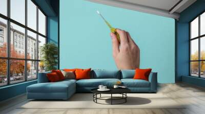 Repair concept. Female hand holds a screwdriver on a blue studio background. Wall mural