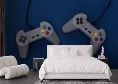 Retro gamepads on classic blue background. Retro gaming. Color 2020. Top view. Wall mural