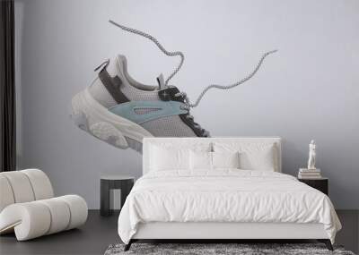 Sports sneaker with flying laces on gray background Wall mural