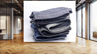 Stack of Many jeans pants on white background Wall mural