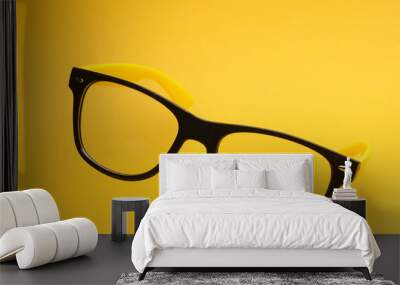 Stylish fashion eyeglasses on yellow background Wall mural