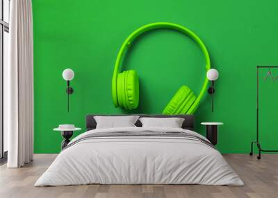 Wireless headphones on dark green background. Top view. Wall mural