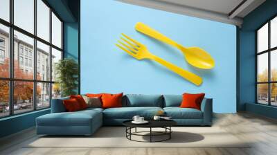 Yellow Plastic fork and spoon on yellow background. Wall mural