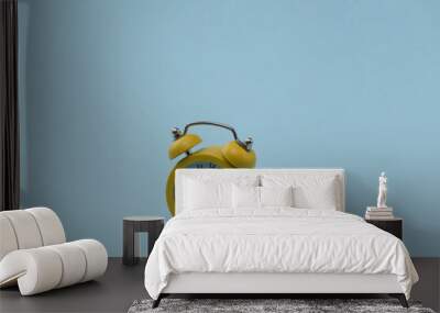 Yellow retro alarm clock on blue background. Wall mural