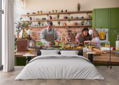 Happy two kids girls have a fun time with their parents at the kitchen island they prepare together the dinner the little girl helping her mom to cook some delicious food Wall mural