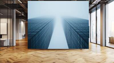 Looking up at modern skyscrapers with glass facades under a bright blue sky and fluffy white clouds in an urban city setting Wall mural