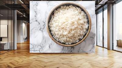 A wooden bowl filled with cooked white rice sits on a marble countertop.  The rice is fluffy and ready to be served.  The bowl is  overhead view. Wall mural