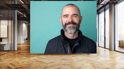 Confident Middle-Aged Man with Beard in Black Jacket Against Teal Background for Professional Use Wall mural