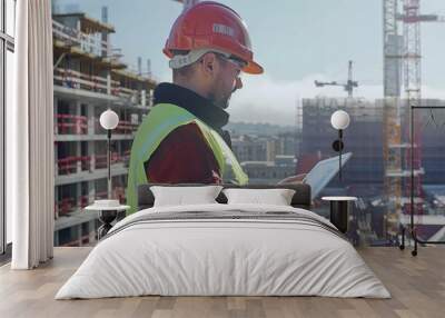 Construction Foreman Reviewing Architectural Plans at Building Site for Project Management Wall mural