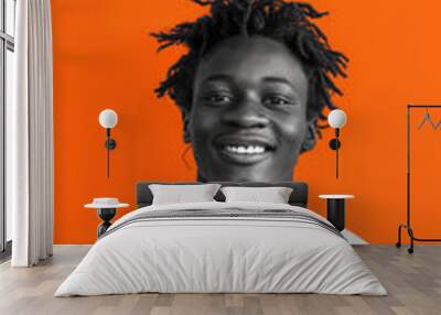 Energetic Smiling Young Man Against Bold Orange Background for Vibrant Design Use Wall mural