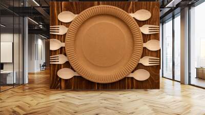 Wooden forks and spoons and paper plate on wooden background Wall mural