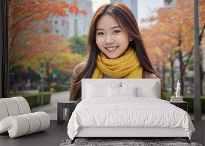 Attractive, lively Asian woman in casual attire outside. Portrait of girl in brown jacket and yellow scarf on urban street during fall. Wall mural