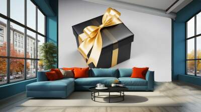 Black gift box wrapped in a shiny gold ribbon isolated on white background Wall mural