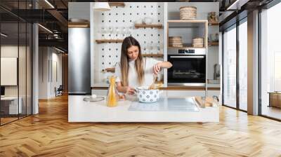 Cooking - Young woman with spaghetti on stove cooking Italian cuisine. University student or business woman making a lunch in domestic kitchen. Fast preparation of food on busy day. Wall mural