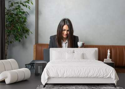 One young businesswoman sitting in cafeteria taking a coffee break while working online on laptop computer. Business female professional occupation e-commerce and remotely finance and economy research Wall mural