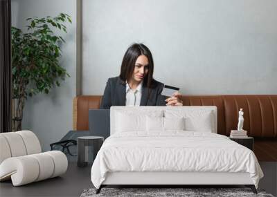 One young businesswoman sitting in cafeteria taking a coffee break while working online on laptop computer. Business female professional occupation e-commerce and remotely finance and economy research Wall mural