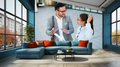 Business team of two young successful happy business people working together and smiling. Discussing business plans and wearing elegant suits and modern glasses Wall mural