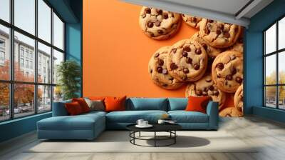 A pile of chocolate chip cookies on an orange background   Wall mural