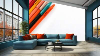 A collection of colorful pens placed diagonally on a white desk creating a vibrant and composition that inspires creativity and design Wall mural