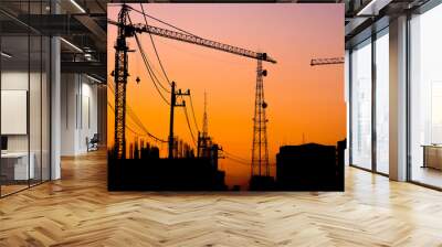 silhouette of building under construction with crane at sunset Wall mural