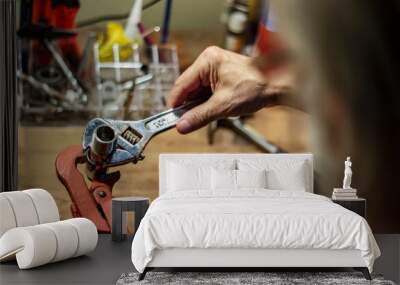 Male using a wrench tool to tighten a metal pipe part Wall mural