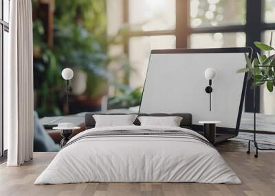 A businesswoman or student using a laptop computer to study online, work remotely, and explore the web is shown staring at a white mock-up blank screen. Display template for a mockup website. above th Wall mural