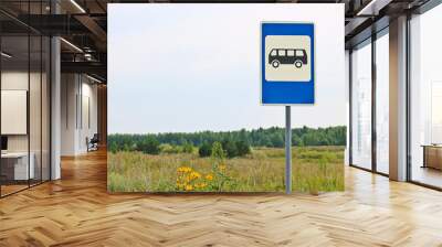 Road sign Public transport stop on the background of the summer landscape. Summer meadow with flowers and grass. Wall mural