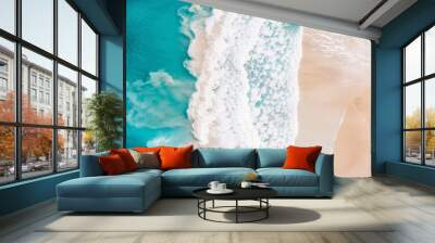 Overhead view of tropical ocean shore on a sunny day with turquoise sea, white waves, and yellow sand. Wall mural