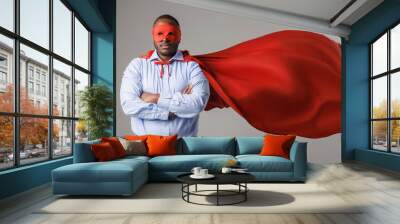 serious african american man in superhero costume folding his arms isolated on white background Wall mural